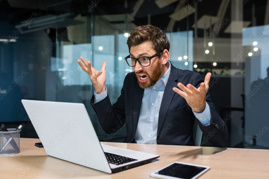 Angry and angry businessman talking on video call, talking to colleagues and shouting quarrel, mature boss working inside modern office building, senior man with laptop and beard.