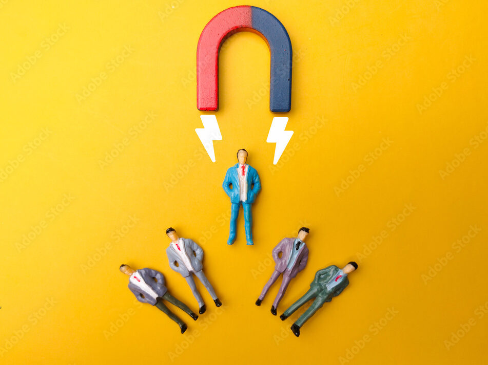 Businessman attracts by magnet on a yellow background. Business and leadership concept.