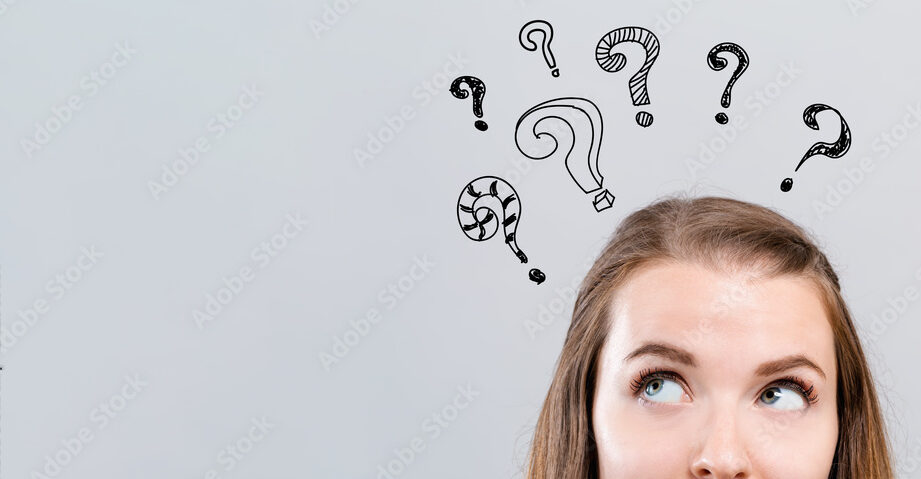 Hand draw question marks with young woman looking upwards on a gray background