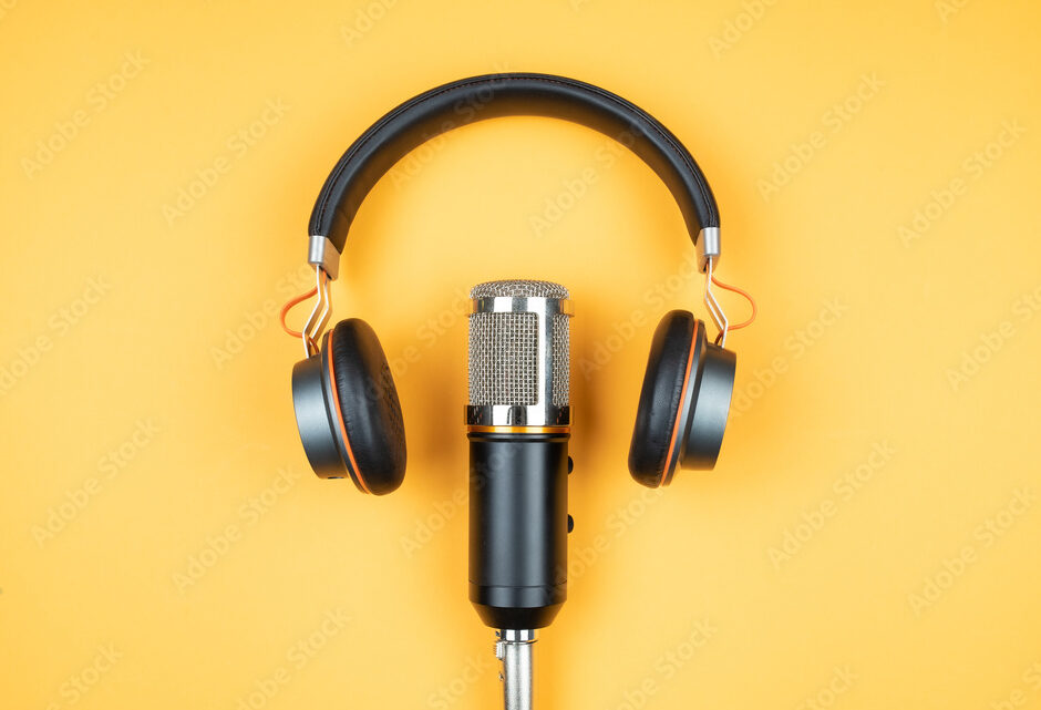 podcasting concept, directly above view of headphones and recording microphone on orange background