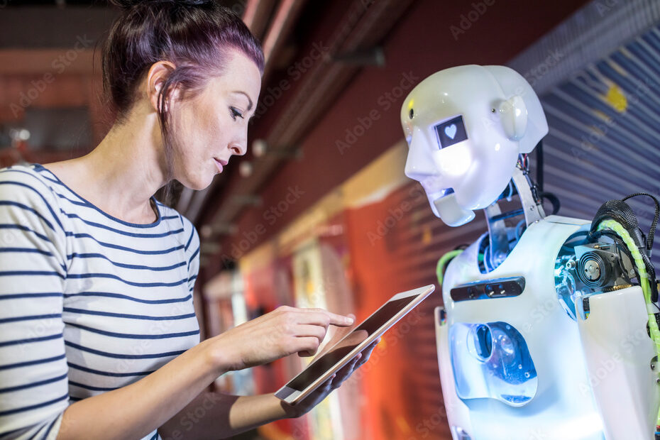 Technician programming human robot through tablet PC at workshop