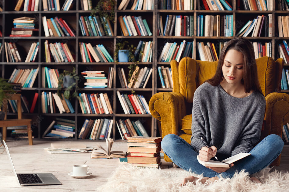 Young woman writer in library at home creative occupation sitting writing notes